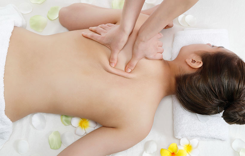 A woman enjoys a relaxing back massage in a serene spa environment